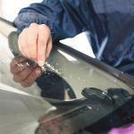 Windscreen replacement UK - worker fixing and repairing a windshield